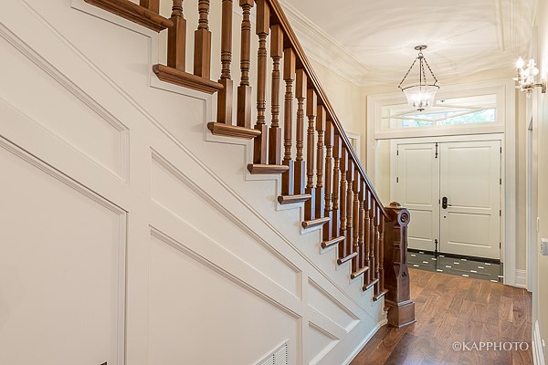 a staircase in a house with white walls and a wooden railing