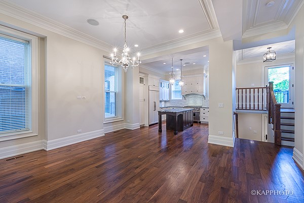a kitchen and living room with hardwood floors and a chandelier