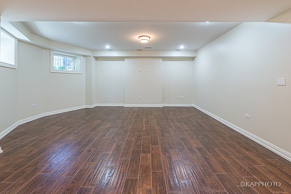 an empty living room with wood floors and white walls