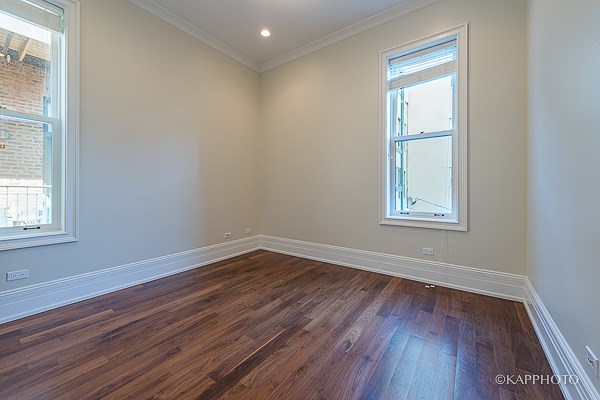 an empty room with wooden floors and a window