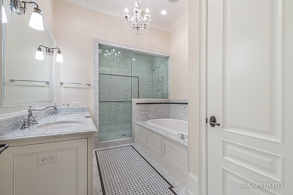 a white bathroom with a tub and a shower and a sink
