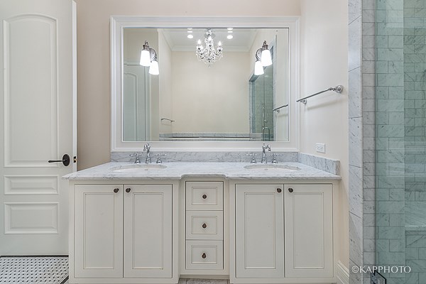 a white bathroom with two sinks and a mirror