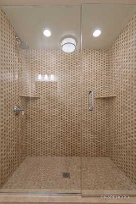 a large shower with a glass door in a bathroom