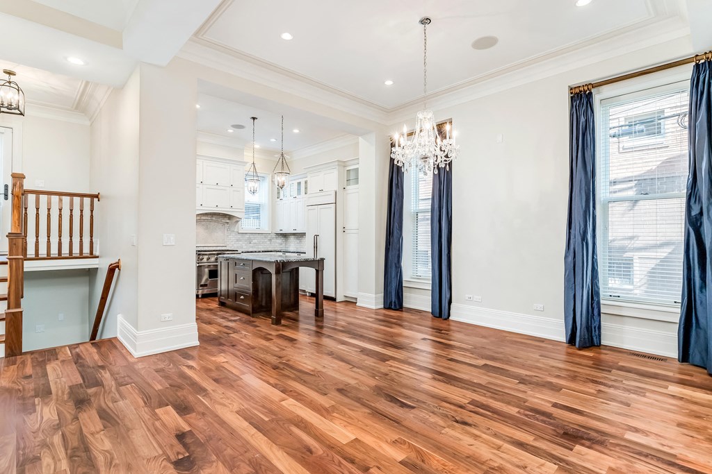a living room with a dining room and a kitchen with wood floors