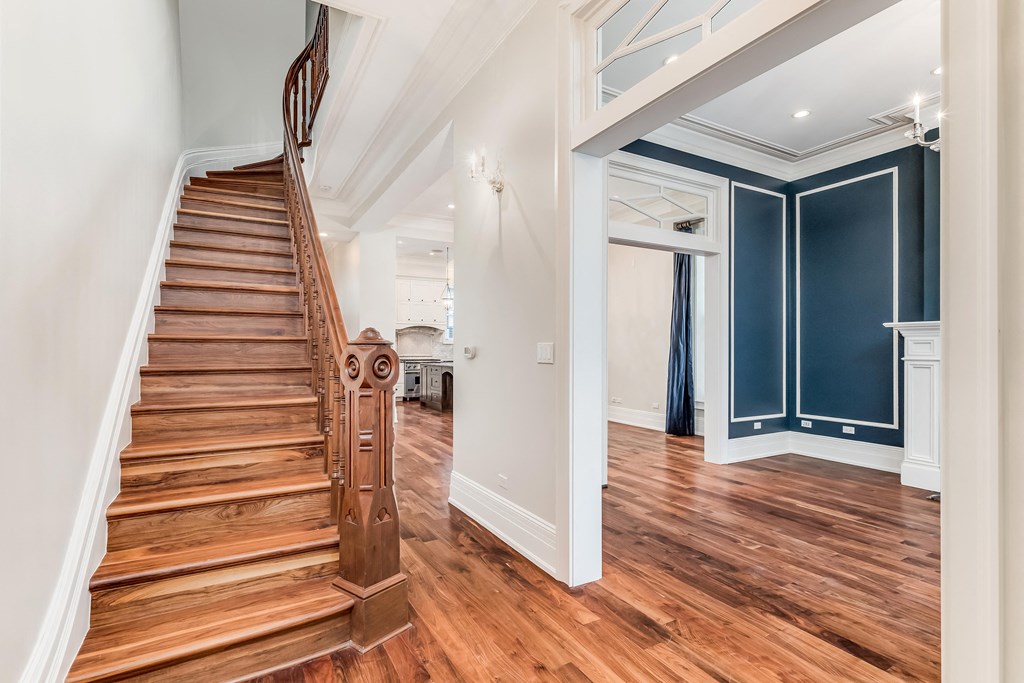 a living room with a staircase and a blue wall and a wooden floor