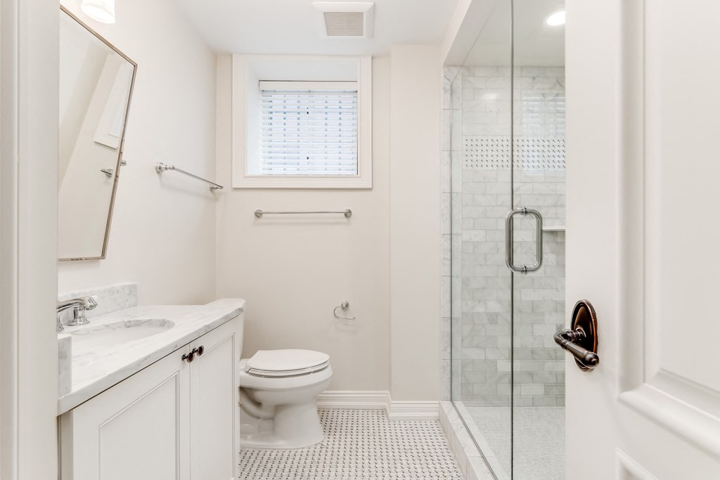 a white bathroom with a shower toilet and sink
