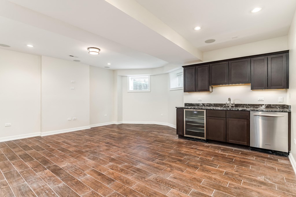 an empty kitchen and living room with a stainless steel stove and refrigerator