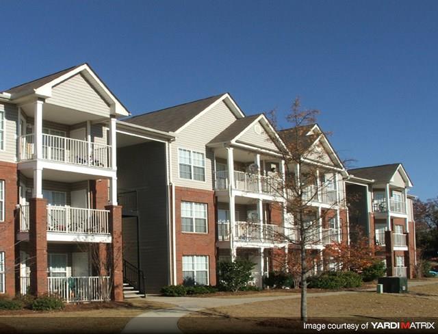 Apartment building with red brick and white trim.