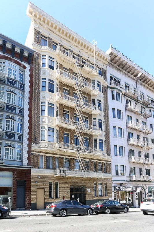 a tall building with a fire escape on a city street