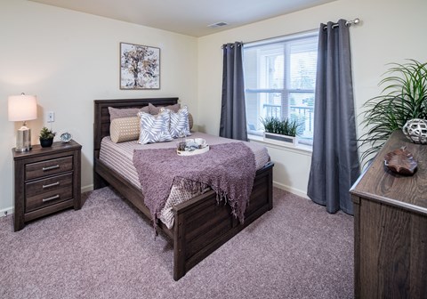 an empty bedroom with a bed and a window