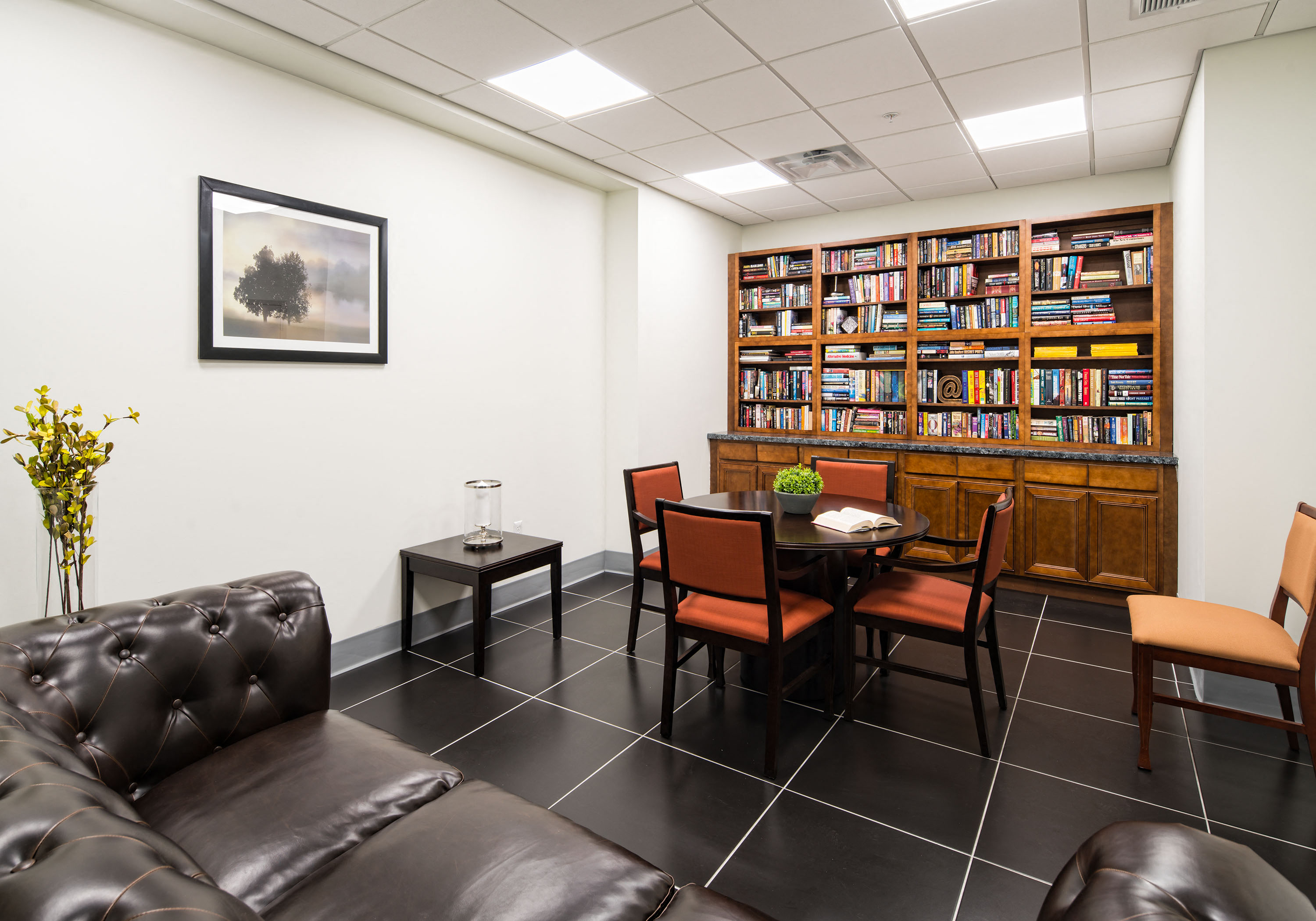 a living room with a table and chairs and a library