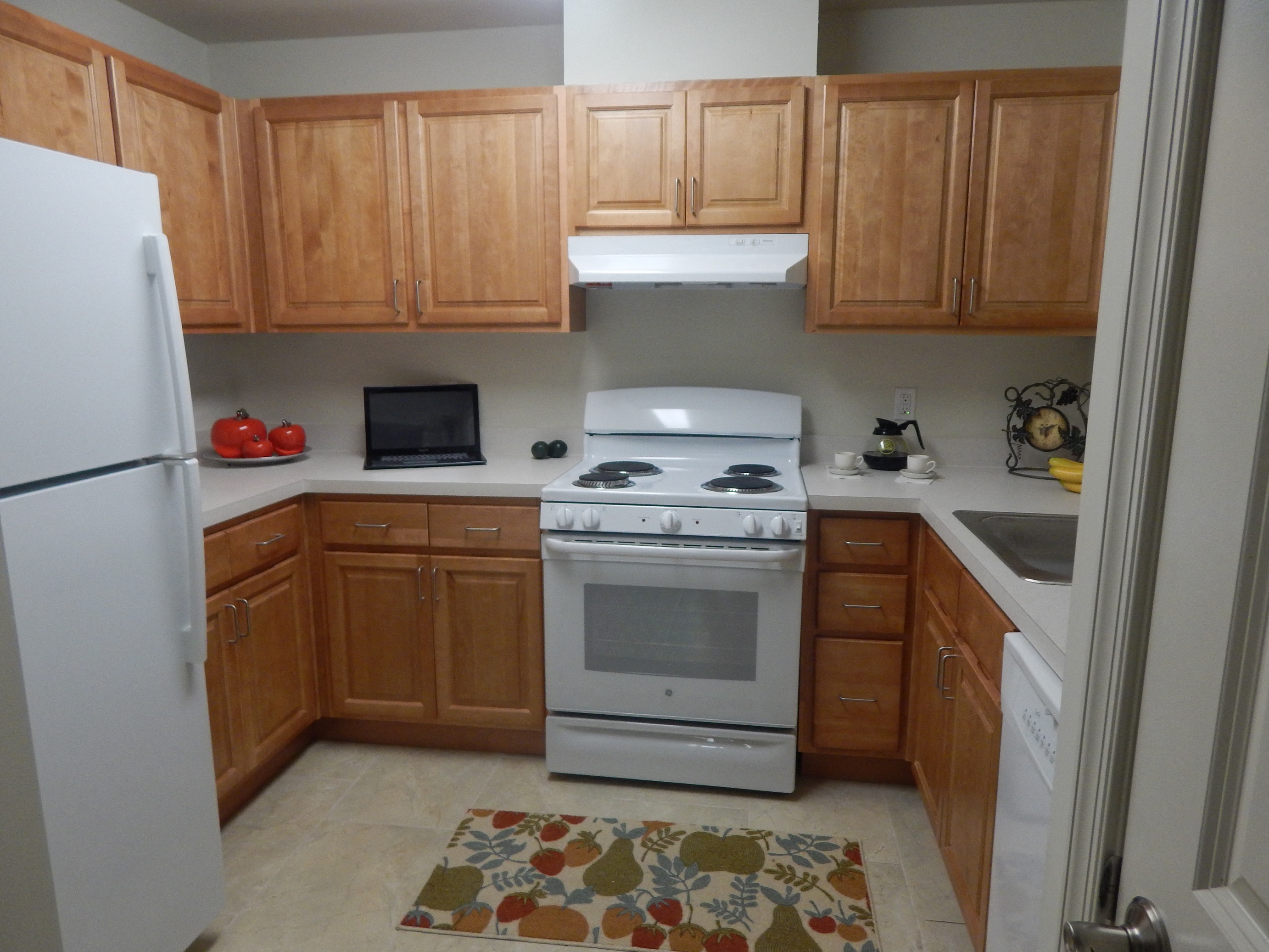 a kitchen with wooden cabinets and a white stove and refrigerator