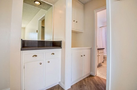 a kitchen with white cabinets and a mirror