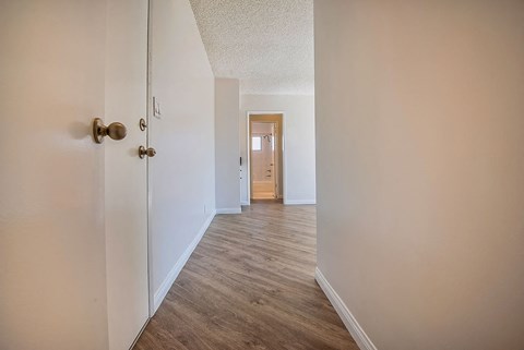 a hallway with a door open to a bedroom and a bathroom
