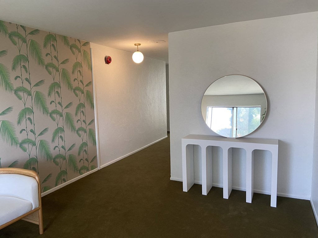 a room with a mirror on the wall and a white table