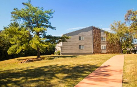 a house with a tree and a sidewalk