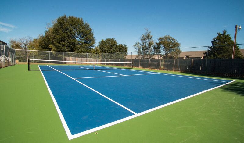 a blue and green tennis court with a fence