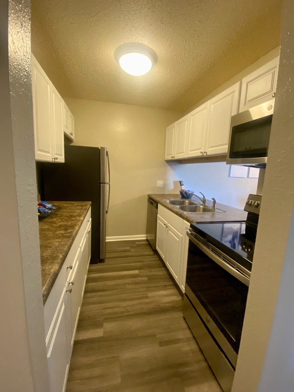 a kitchen with white cabinets and black appliances