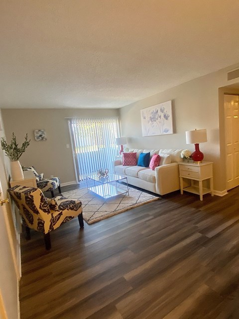 the living room of an apartment with a couch and a chair