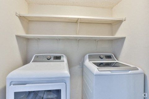two washing machines in an empty laundry room