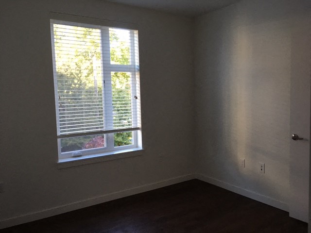 an empty room with a window and a wood floor