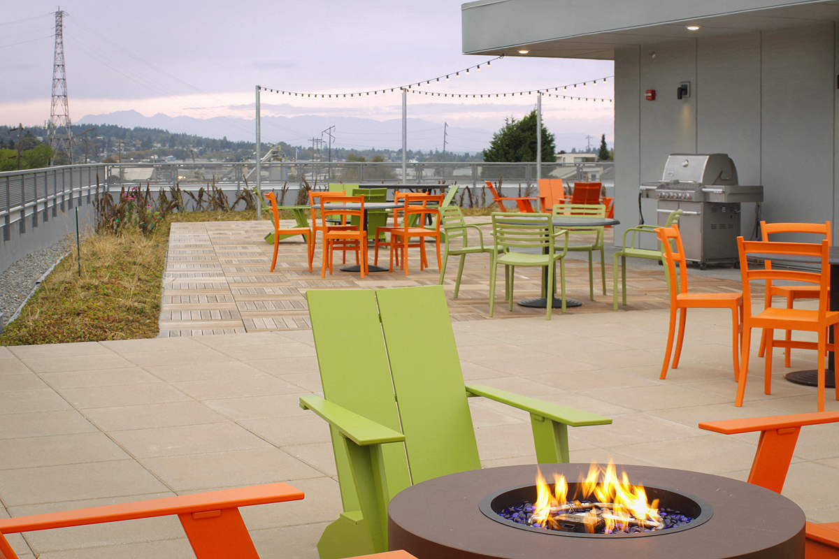 a patio with tables and chairs and a fire pit