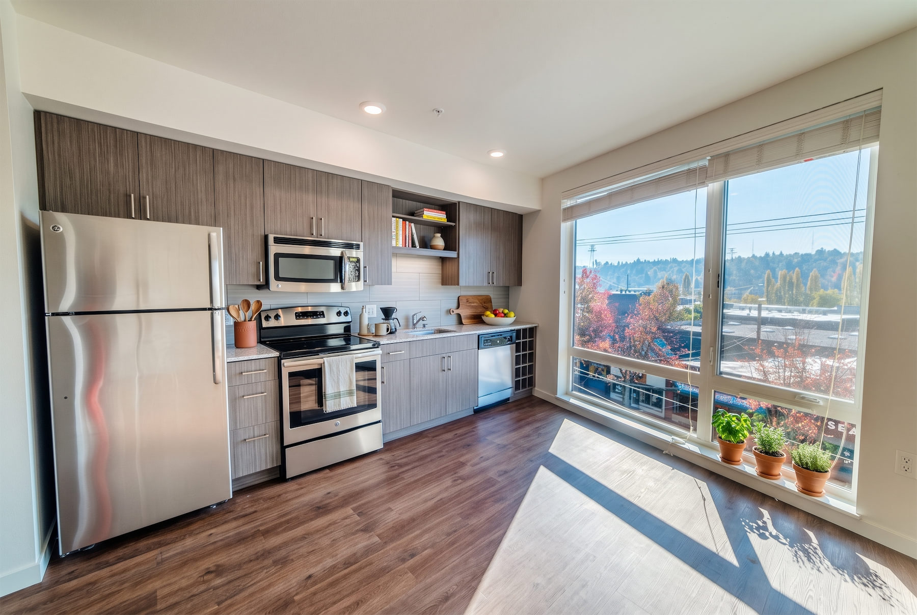 A modern kitchen with stainless steel appliances and wooden floors.