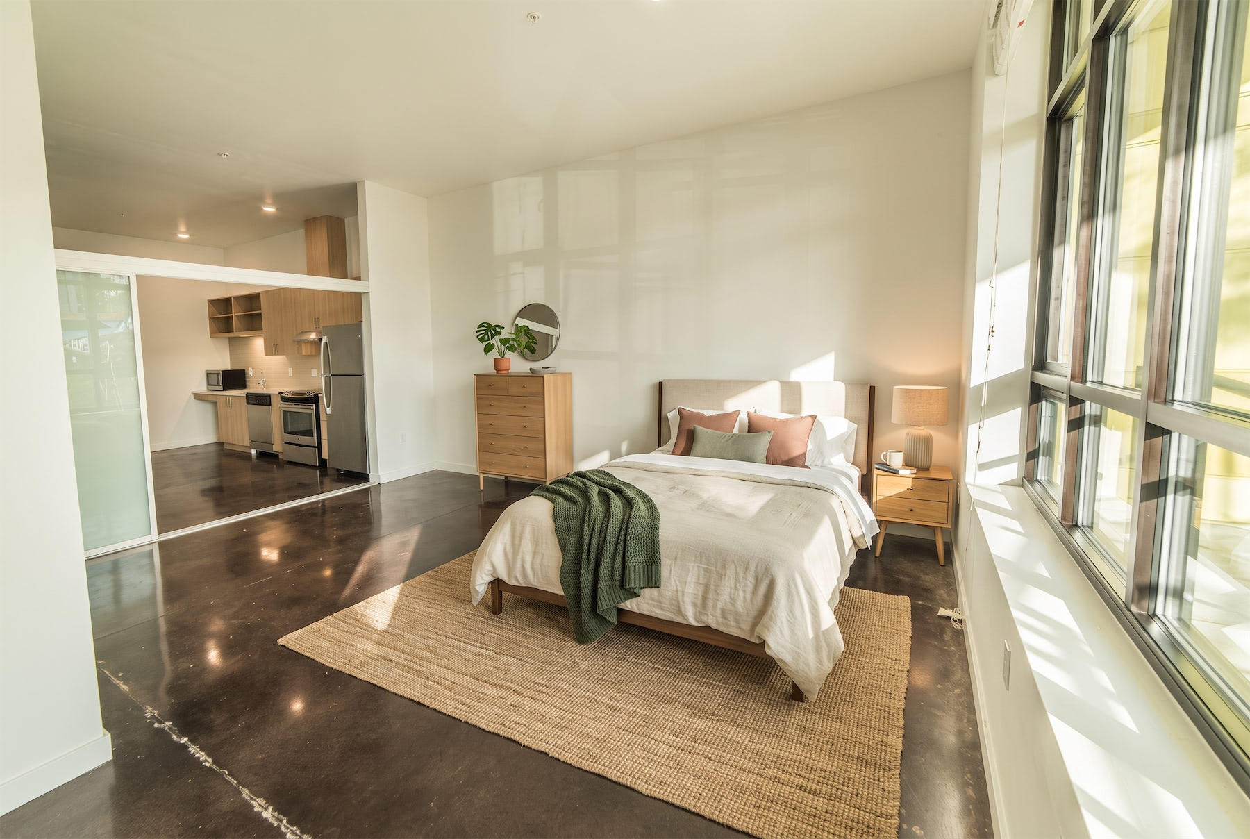 A bedroom with a large bed and a green blanket.