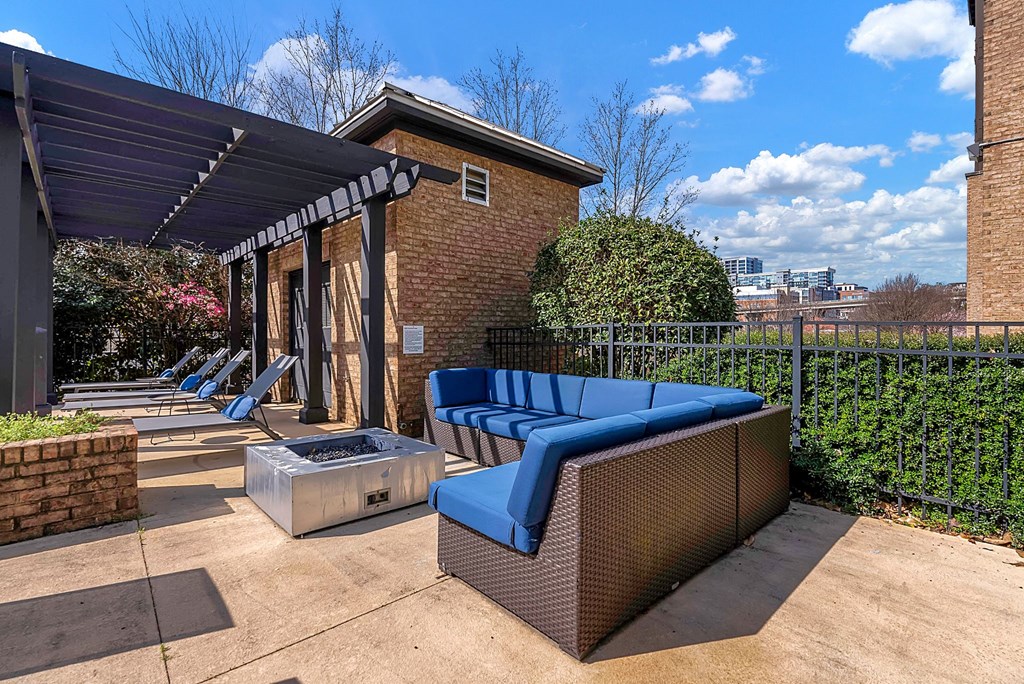 a patio with a blue couch and a fire pit