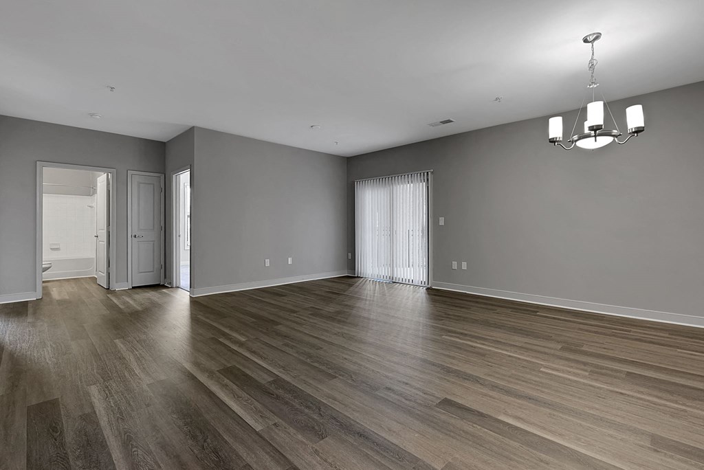 an empty living room with wood floors and grey walls