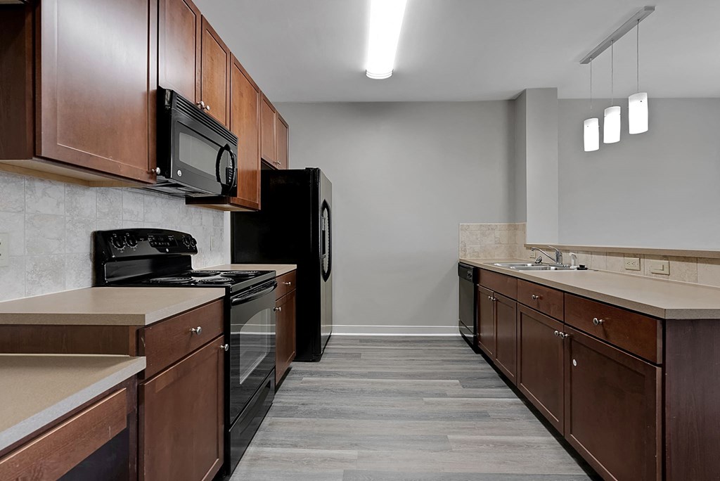 a kitchen with wooden cabinets and black appliances