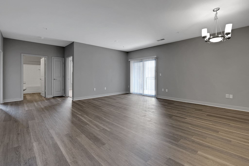 an empty living room with wood floors and grey walls