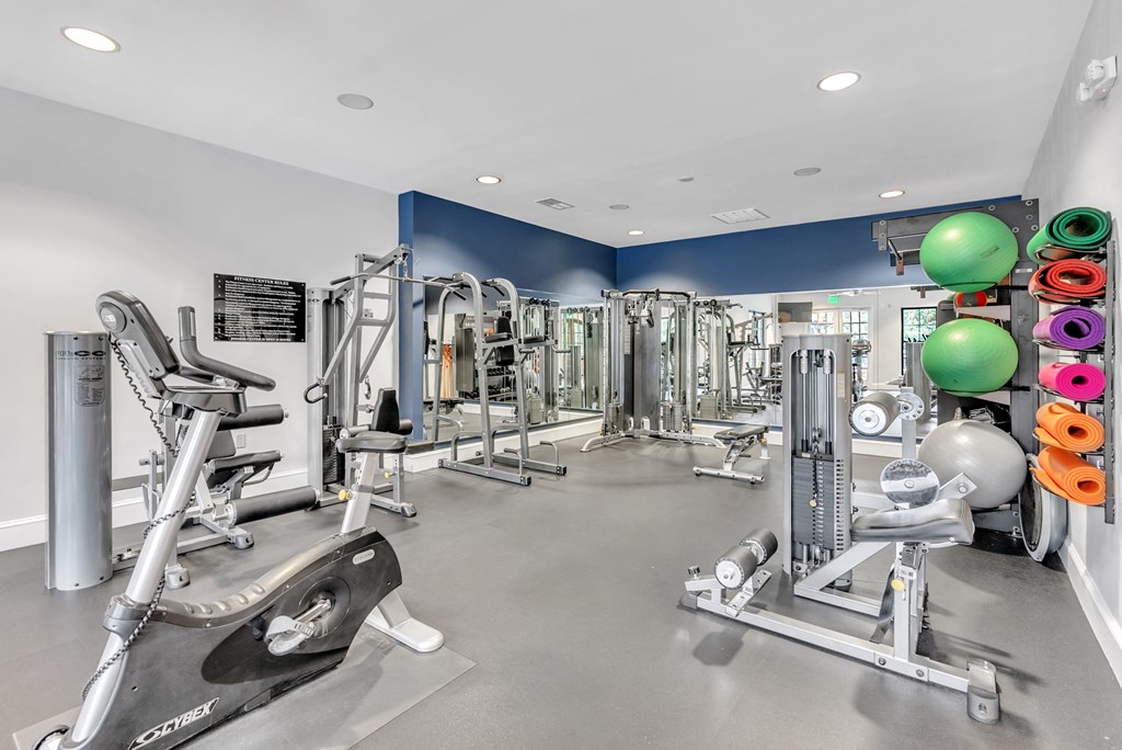a gym with weights and cardio equipment in a building with blue walls