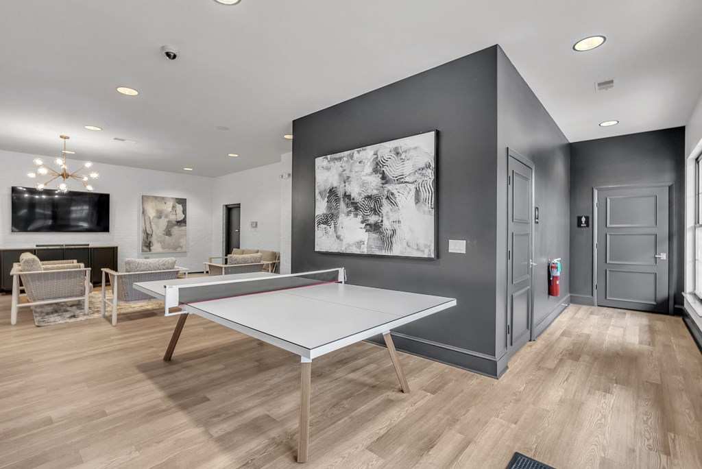 a games room with ping pong tables and a tv