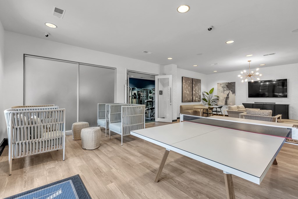 a living room with a ping pong table and a tv