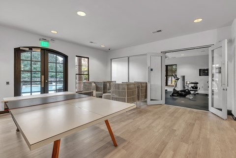 a ping pong table in the center of a room with a gym in the