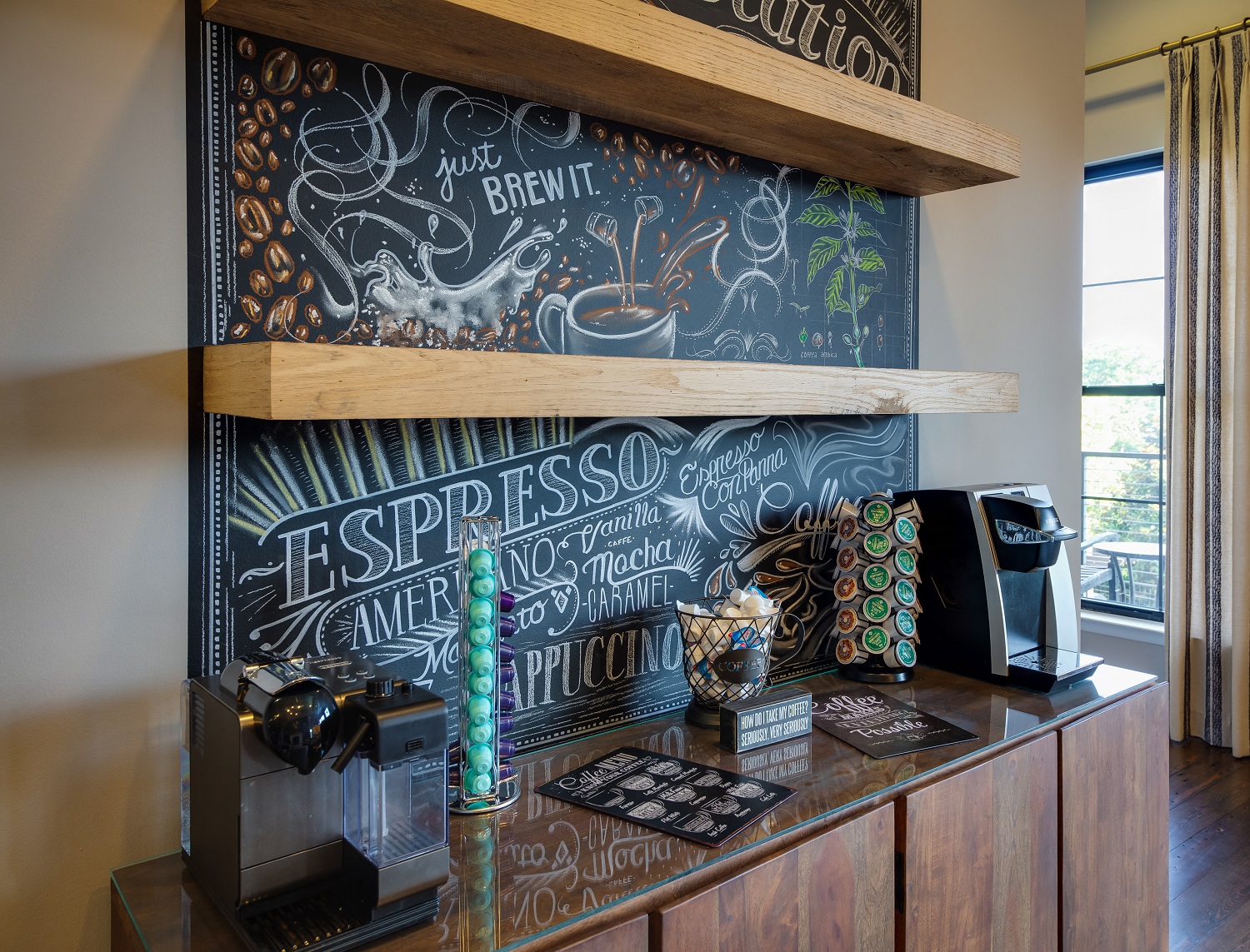 a coffee bar with a chalkboard wall behind it with writing on it