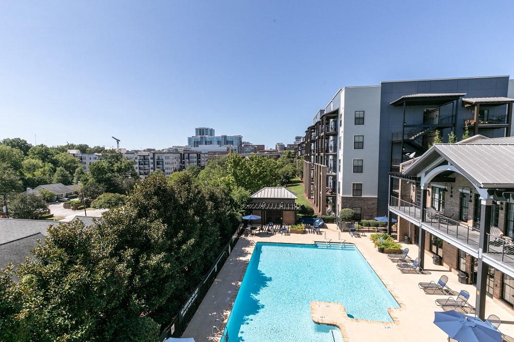 a swimming pool at a hotel with a city in the background