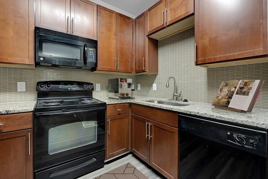 a kitchen with black appliances and wooden cabinets