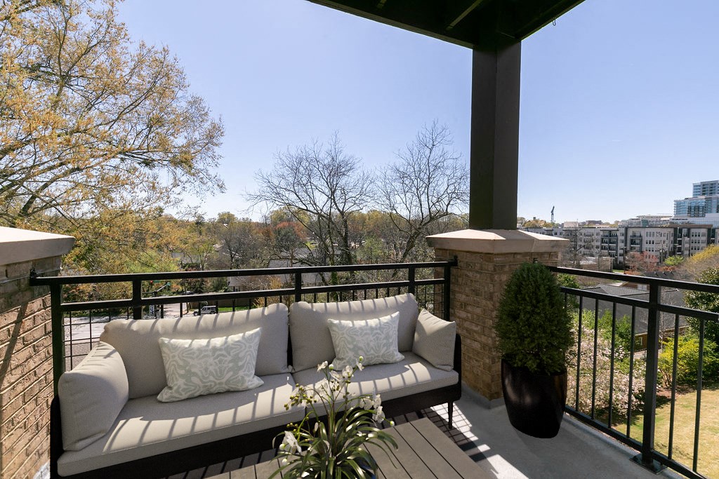 a porch with a couch and a city in the background