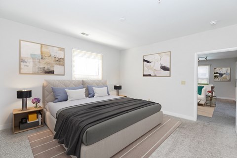 a bedroom with a bed and paintings on the wall