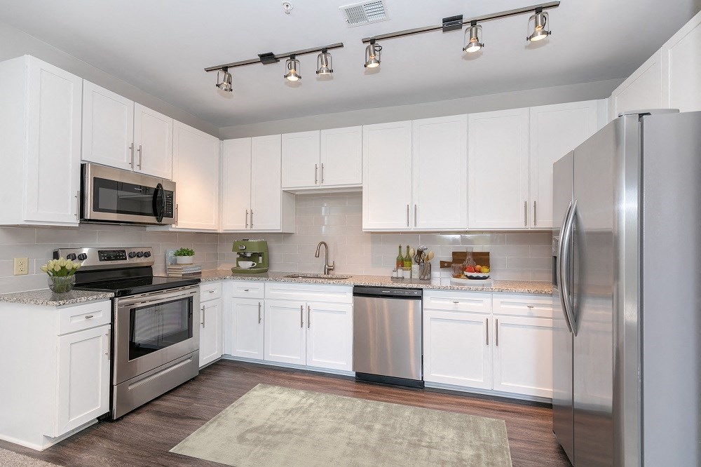 a kitchen with stainless steel appliances and white cabinets