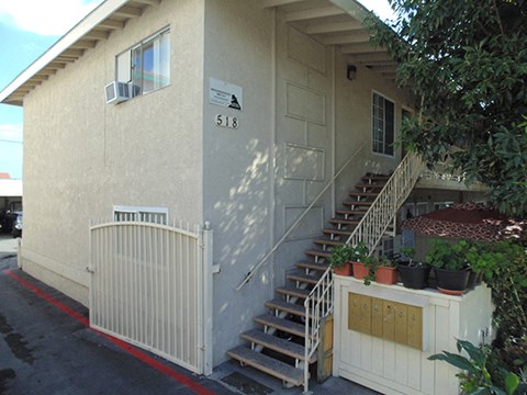 the front of a house with stairs and a gate