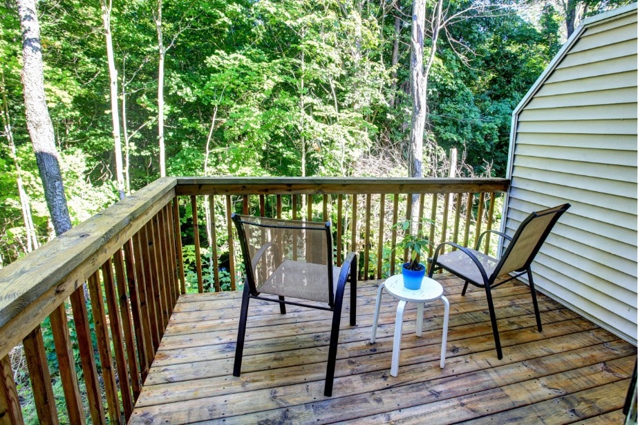 a deck with two chairs and a table