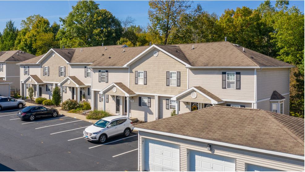 a row of houses with cars parked in a parking lot