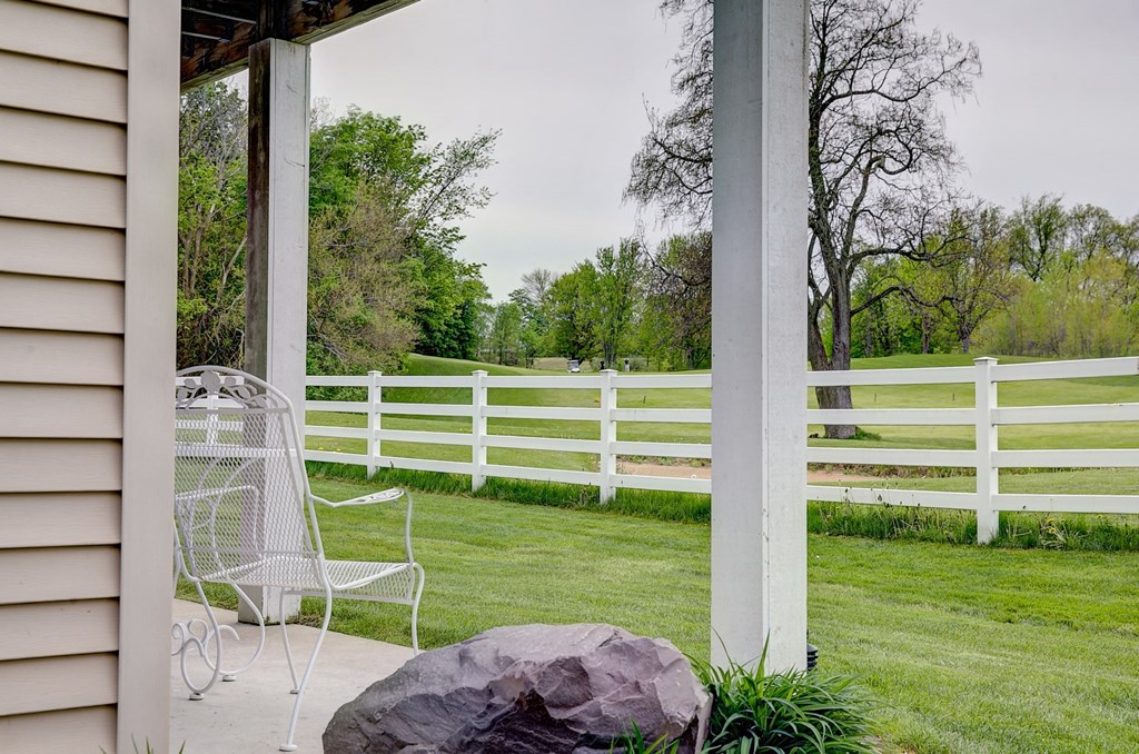 a porch with a lawn and a white fence
