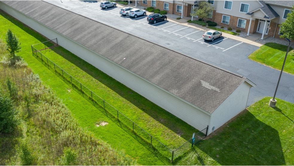 an aerial view of a building with cars parked in a parking lot