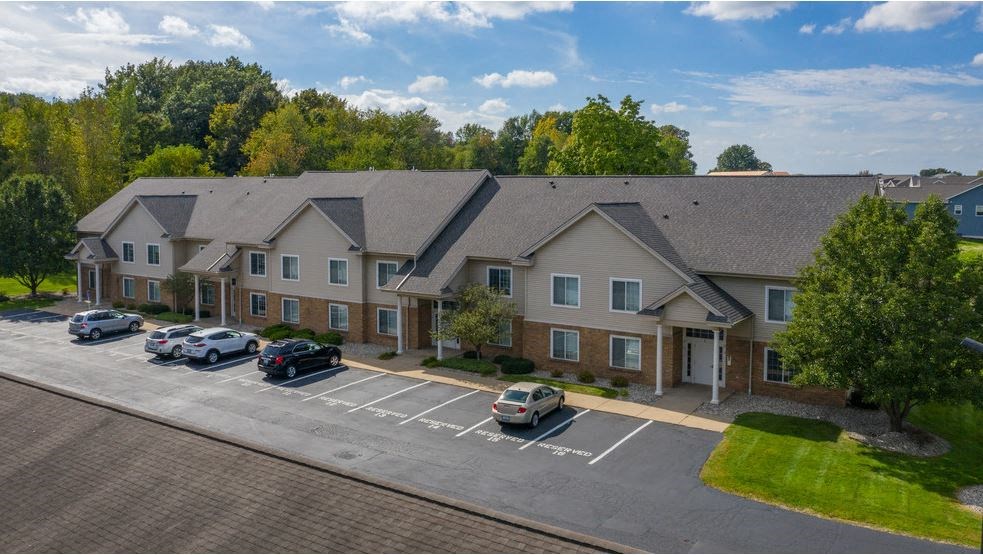 a large apartment building with cars parked in a parking lot
