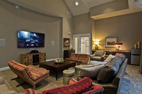 a living room with couches and chairs and a tv