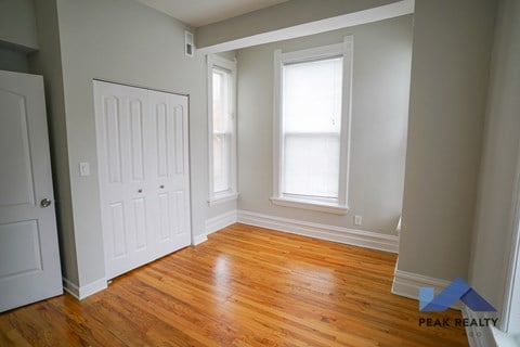 A room with a wooden floor and a white door.